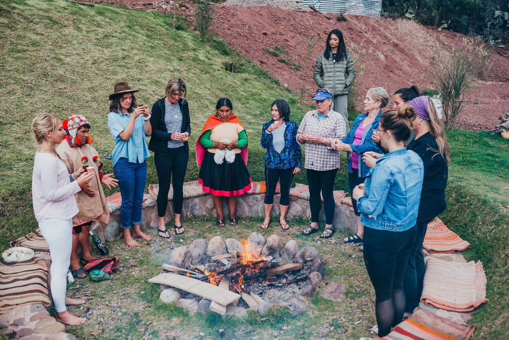 Retreat participants and local Andean people in traditional dress gather around a campfire for a ceremony in the Sacred Valley.